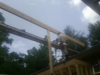 Carpenter setting a ridge beam over a new addition frame — Ice Dam Removal by Roofing Brothers in Hudson